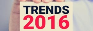 hand holding up a sticky note with trends 2016 on them